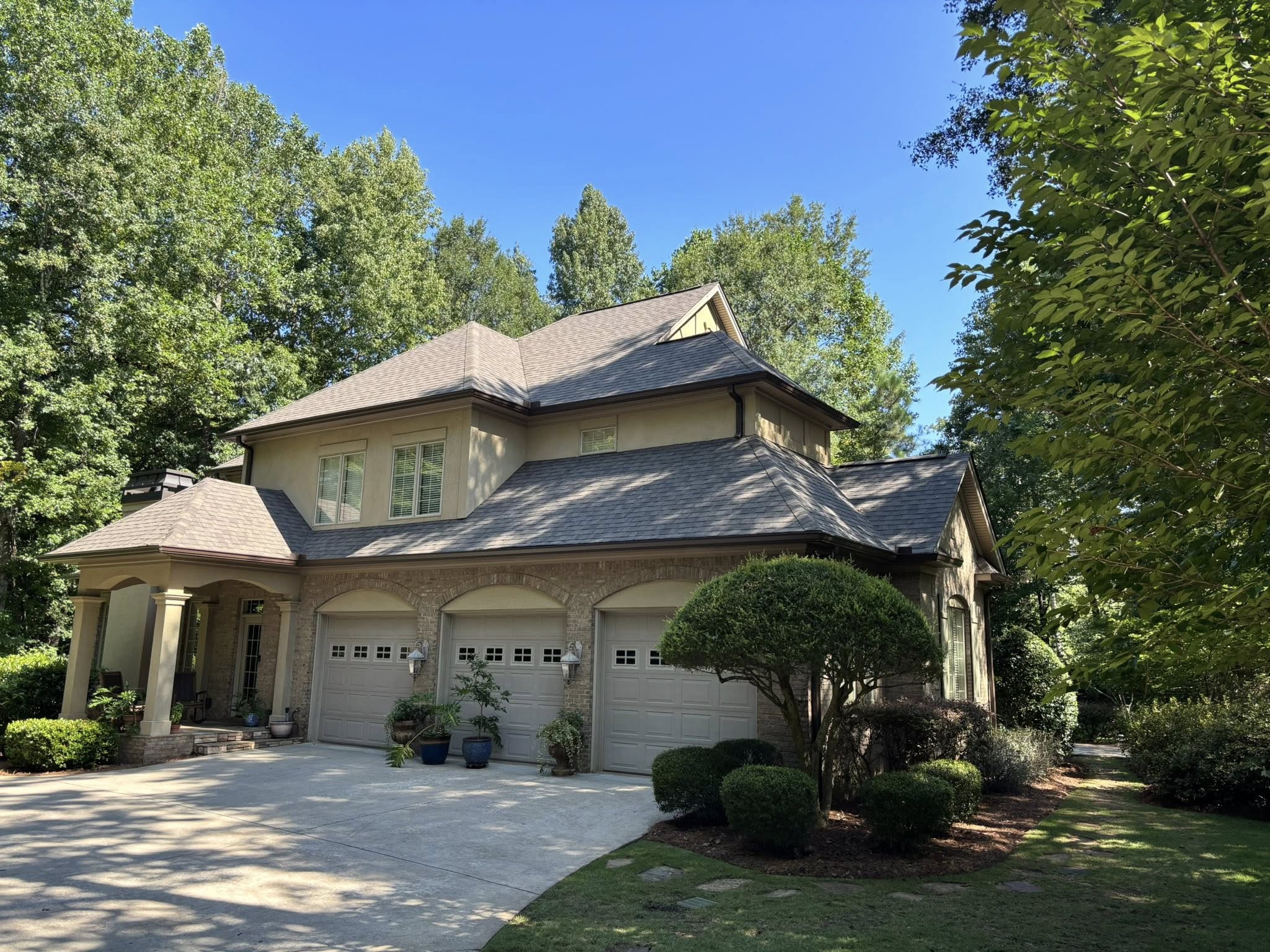Happy family in front of their home with a new Summit Roofing roof